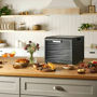 Excalibur 10-Tray Performance Digital Dehydrator on a kitchen counter surrounded by dried snacks and fresh ingredients